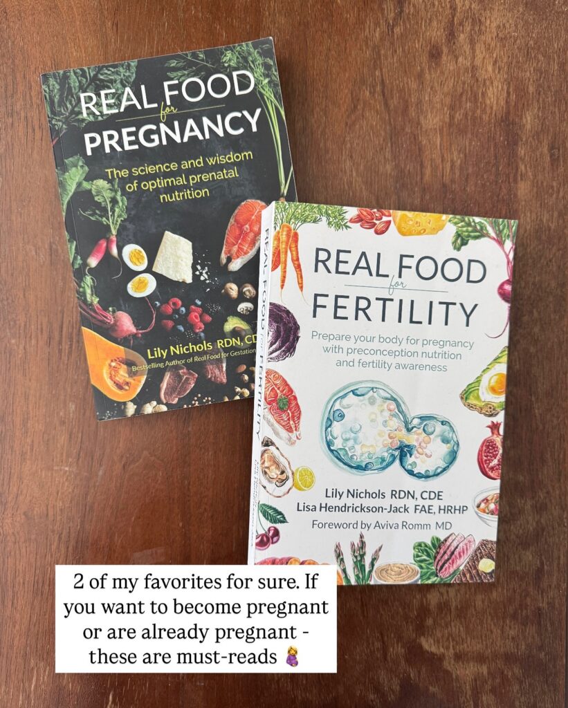Two nutrition books photographed on a wooden surface. The book on the left is "Real Food for Pregnancy: The Science and Wisdom of Optimal Prenatal Nutrition" by Lily Nichols RDN, CDE, with a dark cover featuring whole foods including eggs, salmon, berries, and vegetables. The book on the right is "Real Food for Fertility: Prepare Your Body for Pregnancy with Preconception Nutrition and Fertility Awareness" by Lily Nichols RDN, CDE and Lisa Hendrickson-Jack FAE, HRHP, with a light cover featuring illustrated whole foods and a cell fertilization image. A text overlay reads "2 of my favorites for sure. If you want to become pregnant or are already pregnant - these are must-reads."
