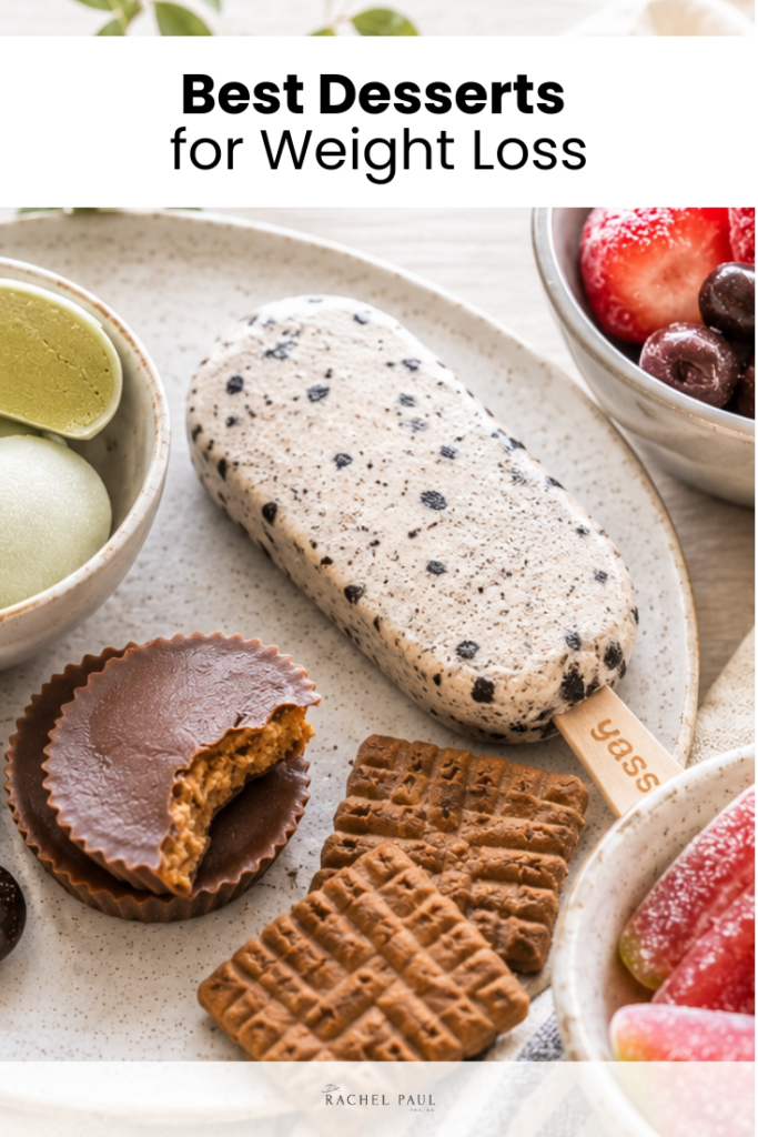 A platter of assorted sweets including a cookies and cream popsicle, chocolate peanut butter cups, cookies, matcha ice cream, fresh berries, and fruit jellies.
